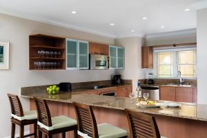a kitchen with a island with chairs and a counter top at Alexandra Resort- All Inclusive in Grace Bay
