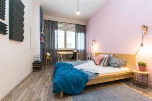 ein Schlafzimmer mit einem Bett mit blauer Decke in der Unterkunft Apartments Ve Smeckach 27 in Prag