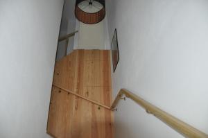 a wooden staircase with a clock on the wall at Hostel Eleven in Esposende