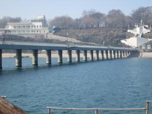 a bridge over the water next to a beach at Julia Garden in Burgas City