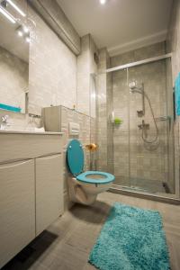 a bathroom with a blue toilet and a shower at Apartament Criss Lotus in Mamaia