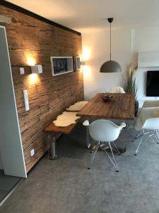 a dining room with a wooden wall with a table and chairs at Wander- und Aktivchalet in Birkenfeld