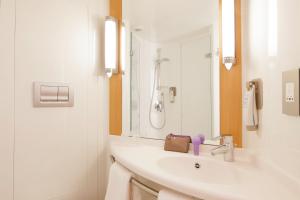a white bathroom with a sink and a shower at ibis London Shepherds Bush - Hammersmith in London