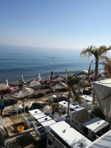 a beach with chairs and umbrellas and the ocean at Olympic Star in Hersonissos