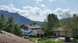 ein Haus in einem Dorf mit Bergen im Hintergrund in der Unterkunft Ferienwohnung Johanna in Schwangau