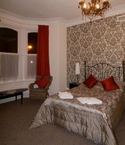 a bedroom with a bed and a chair and a window at Glendale Hotel in Cardiff +16 photos
