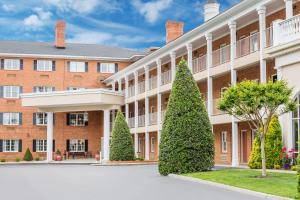 a large brick building with trees in the courtyard at Days Inn by Wyndham Williamsburg Historic Area in Williamsburg