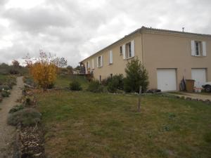 a house with a grass yard next to a building at maison la croix chambre chez l ' habitant in Marsac