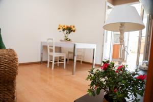 un soggiorno con tavolo, lampada e fiori di Casa Bea a Quartu SantʼElena
