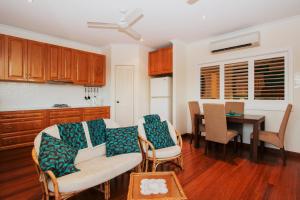 eine Küche mit einem Sofa und einem Tisch mit Stühlen in der Unterkunft Reflections Broome in Broome