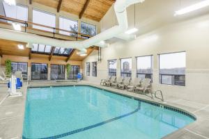 a swimming pool in a building with windows and a ceiling at Super 8 by Wyndham Grants Pass in Grants Pass