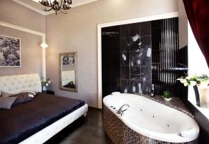 a bathroom with a bath tub and a bed at City Garden Apartments in Odesa