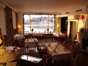 a restaurant with tables and chairs and a large window at Hotel-Restaurant Faustschlössl in Feldkirchen an der Donau