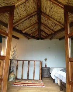 a bedroom with a bed and a wooden ceiling at Cabaña Campestre San Fernando in Iza