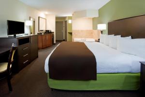 a hotel room with a large bed and a flat screen tv at AmericInn by Wyndham Sibley in Sibley