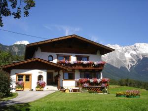 a house with flowers and mountains in the background at Haus Schweigl in Obsteig
