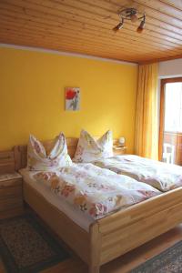 Bett in einem Schlafzimmer mit gelber Wand in der Unterkunft Haus Schweigl in Obsteig
