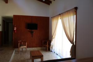 a living room with a window and a table and chairs at Cabañas Pun May in Villarrica