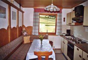 a small kitchen with a table and a window at Haus Schweigl in Obsteig