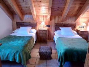 2 camas en una habitación con paredes de madera en Apartamentos Fogaron, en Saravillo