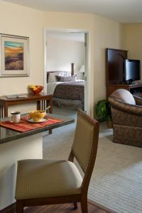 ムキルテオにあるStaybridge Suites Everett - Paine Field, an IHG Hotelのベッドとリビングルームが備わるホテルルームです。