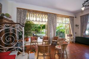 a living room with chairs and a table and windows at Villa Lucia Grande Varenna in Varenna