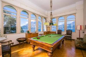 a pool table in a room with windows at Villa Lucia Grande Varenna in Varenna