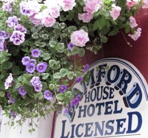 
a sign on a wall with flowers in front of it at Bamford House Hotel in Blackpool
