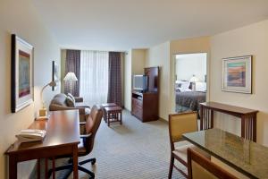 ムキルテオにあるStaybridge Suites Everett - Paine Field, an IHG Hotelのベッドルームとリビングルームが備わるホテルルームです。