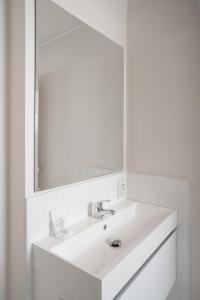 a white bathroom with a sink and a mirror at West Plaza Hotel in Wellington