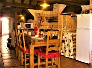 a kitchen with a table and chairs and a refrigerator at Casa Rural Amparo in Mogarraz