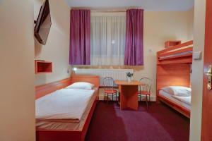 una camera d'albergo con due letti e un tavolo di Hostel Evotel a Zielonka