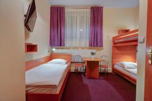 ein Hotelzimmer mit 2 Betten und einem Tisch in der Unterkunft Hostel Evotel in Zielonka