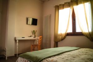 a bedroom with a bed and a desk and a window at Il Marrondindo Bed & Breakfast in Galliano