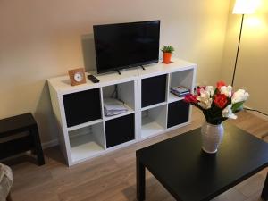a living room with a tv and a vase of flowers on a table at Lakeside View, Perton Village in Wolverhampton