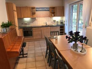 eine Küche mit Holzschränken, einem Tisch und Stühlen in der Unterkunft Haus Fischernetz in Leezdorf