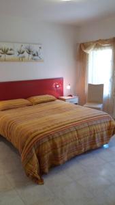 um quarto com uma cama grande e uma cabeceira vermelha em Salvia e Timo Holiday Apartments em Borso del Grappa