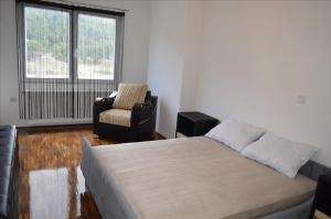 Un dormitorio con una cama y una silla y una ventana. en Apartment Luka, en Ohrid