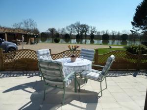 a table and chairs sitting on a patio at Lake Les Landes in Montpon-Ménestérol