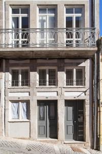 ポルトにあるビナアパルトメンチス リオのバルコニーとドア付きのアパートメントビル