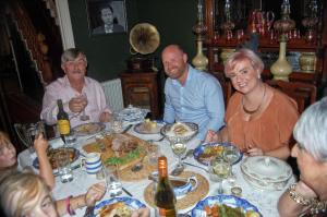 un grupo de personas sentadas alrededor de una mesa comiendo comida en Dylan Thomas House, en Swansea