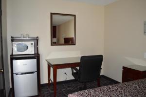 a room with a desk with a microwave and a chair at Economy Inn in Portland
