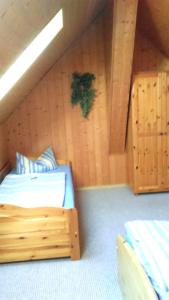 BellinにあるFerienhaus Bellin VORP 2501の木製の壁のベッドルーム1室(ベッド1台付)