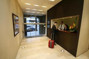 a man and a woman in a lobby with a suitcase at Best Western Plus Hotel Stellar in Sydney