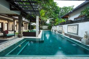 a swimming pool with blue water in a house at Villa Dewata II in Seminyak