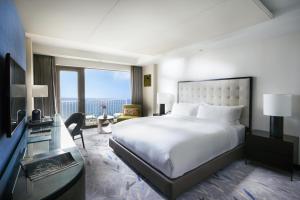 Paradise Hotel Busan في بوسان: غرفة في الفندق مع سرير ومكتب مع نافذة