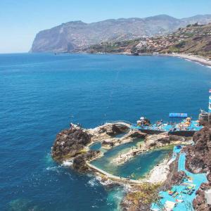 an island in the ocean with people on it at Atouguia Apartment in Funchal