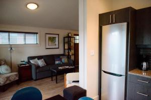 a kitchen and living room with a stainless steel refrigerator at Fish Tales Cottage in Port Renfrew