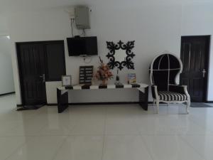 een woonkamer met een tafel en 2 stoelen bij Mess Inn Semarang in Semarang