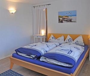 ヴァーレンにあるFerienwohnung Waren SEE 8161のベッドルーム1室(青と白の枕が備わるベッド1台付)